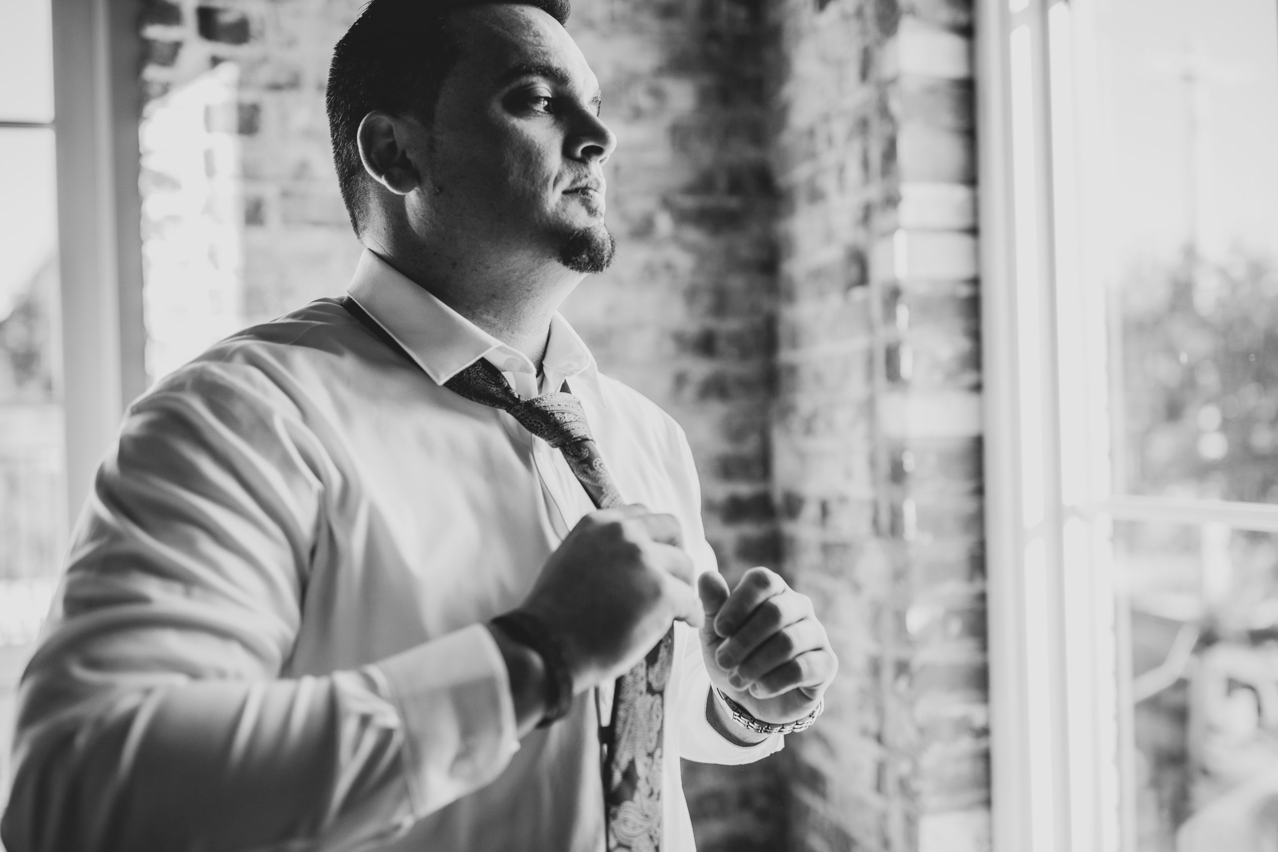 groom putting on a tie
