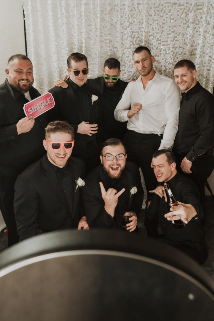 groom and groomsmen at wedding photo booth