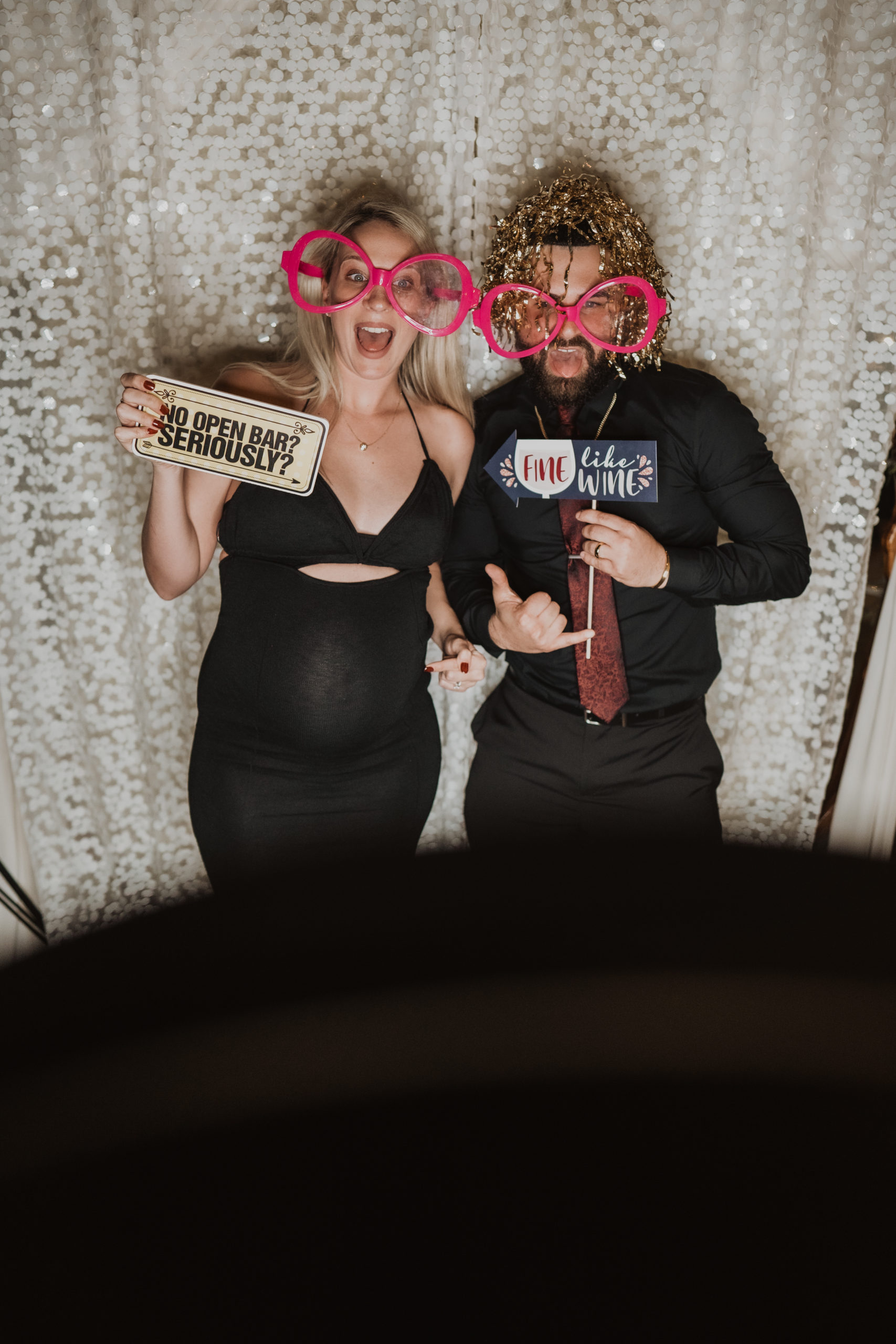 couple with props at wedding photo booth