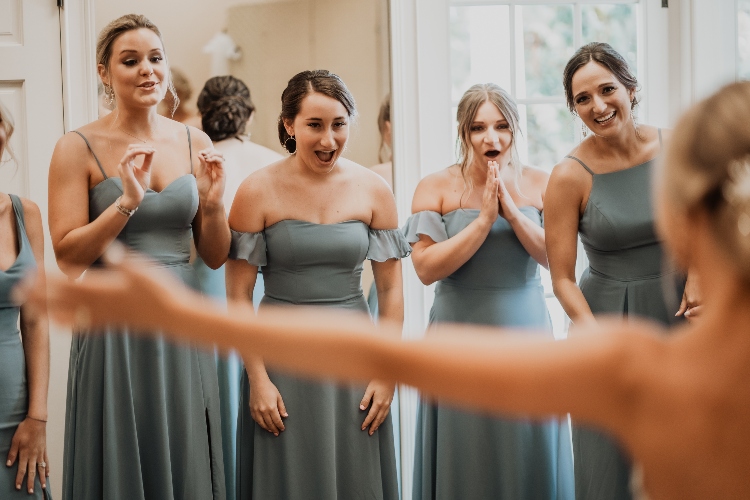  Top Wedding Photography Trends for 2024 - getting the bridal party's reaction to the bride in her dress at wedding